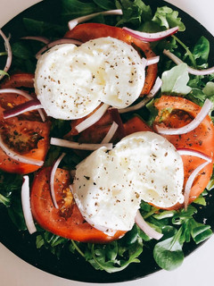 Una foto de Ensalada de canónigos y rúcula con burrata