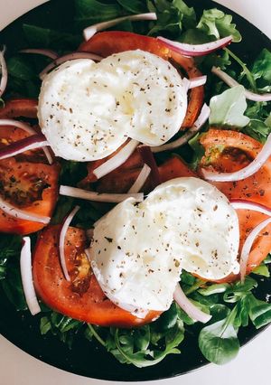 Una foto de Ensalada de canónigos y rúcula con burrata