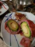 Aguacate relleno, cubierto con tocino ahumado