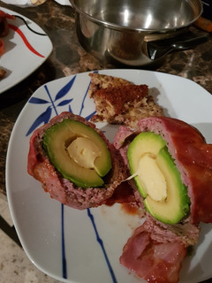Una foto de Aguacate relleno, cubierto con tocino ahumado