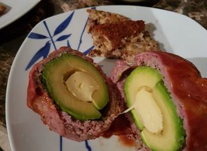 Una foto de Aguacate relleno, cubierto con tocino ahumado