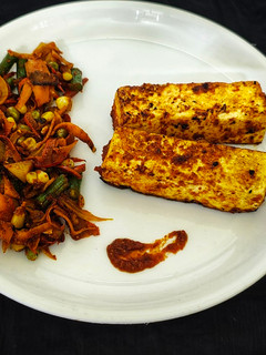 A picture of Peri Peri Paneer Steak with Tossed Vegetables.