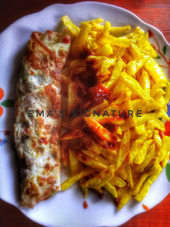 A picture of French Fries with roll fried eggs.