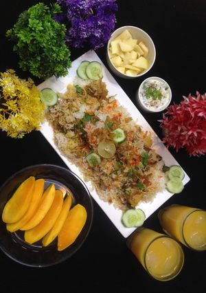 A picture of ChatpatiBombay biryani with tang twist, yogurt salad, mango, apple cubes.