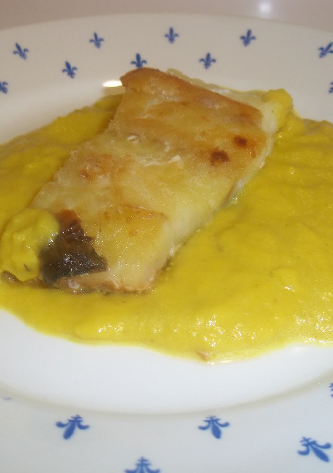 Una foto de Bacalao con salsa de pimientos amarillos y cúrcuma