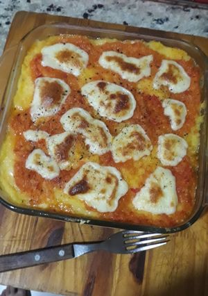 Una foto de Polenta con salsa y queso