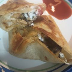 A picture of Leftovers: Lamb and Bean Burrito and a Puddle of Hot Sauce.