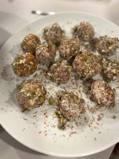 Una foto de Croquetas de queso cabra y dátiles envueltas en leche de coco, semillas y chocolate