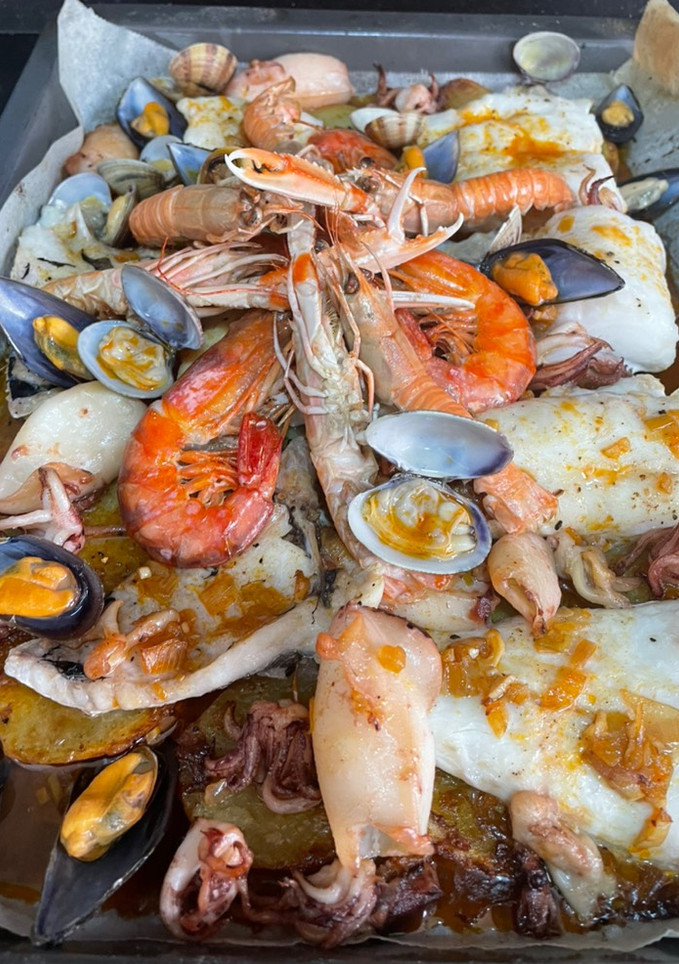 Una foto de Merluza al horno con chipirones 🦑 patatas, mejillones y almejas