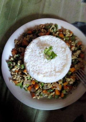 A picture of White rice served with vegetable egg sauce.