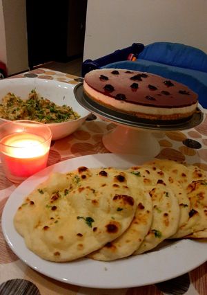 A picture of Tawa Naan with paneer handi and blueberry cheese cake.