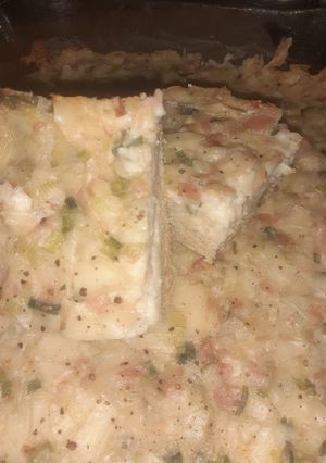 Una foto de Tarta de cebolla de verdeo con paleta y queso