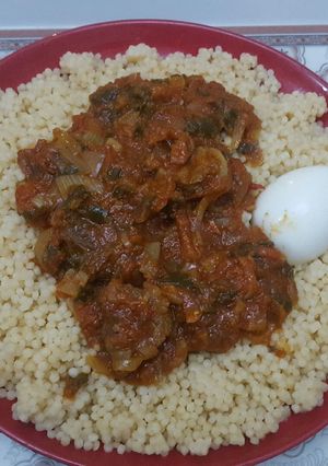 A picture of My favorite couscous with beef stew & spring onions leaf & egg.