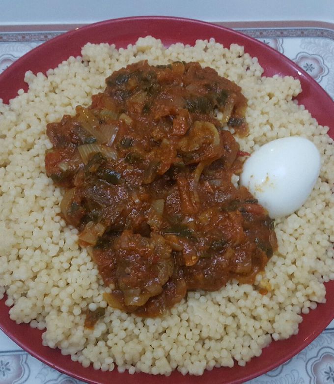 A picture of My favorite couscous with beef stew & spring onions leaf & egg.