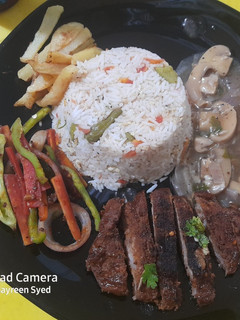 A picture of Beef Steak with Mushroom sauce and egg fried rice 🍚.