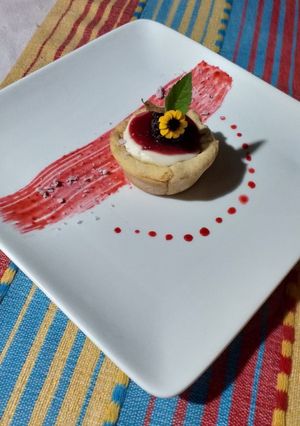 Una foto de Panacota de vainilla y café con coulis de zarzamora