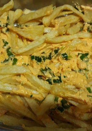 Una foto de Papas fritas con cheddar