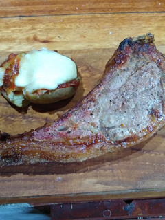 Una foto de Tomahawk con papas estrelladas gratinadas y ketchup casero