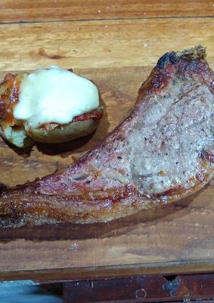 Una foto de Tomahawk con papas estrelladas gratinadas y ketchup casero