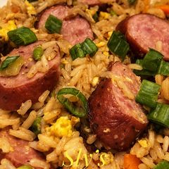 A picture of Fried rice with andouille sausage In Wok.