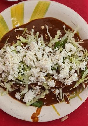 Una foto de Tacos dorados con coloradito