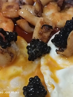 Una foto de Huevos fritos con vieiras, langostinos y sepia