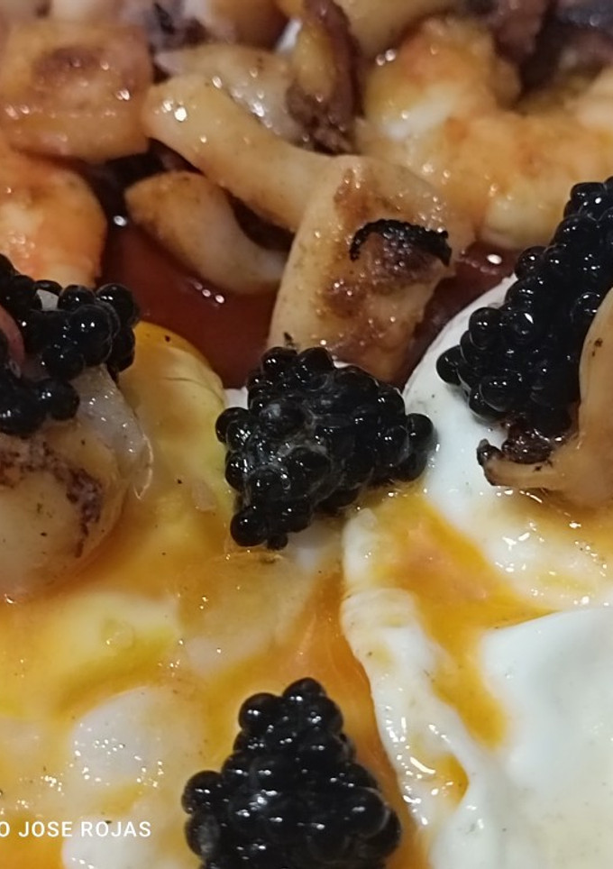 Una foto de Huevos fritos con vieiras, langostinos y sepia