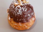 Una foto de profiteroles con cobertura de chocolate