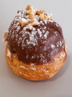 Una foto de Profiteroles de crema con cobertura de chocolate al caramelo