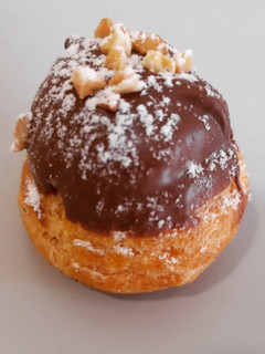 Una foto de Profiteroles de crema con cobertura de chocolate al caramelo