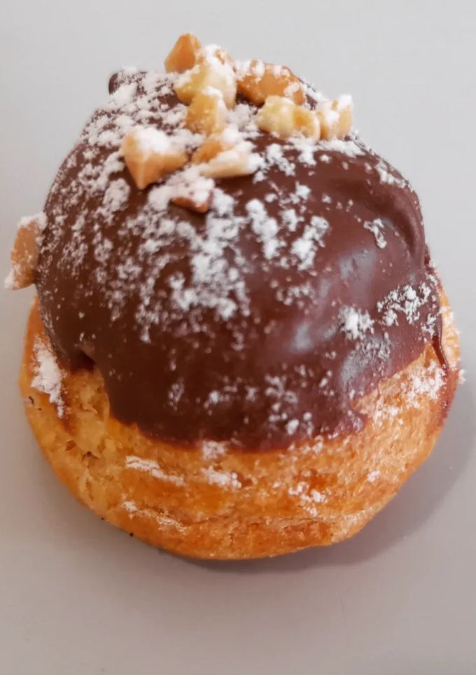 Una foto de Profiteroles de crema con cobertura de chocolate al caramelo
