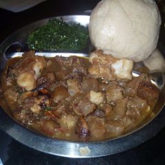 A picture of Boiled orenge with greens and ugali (bone soup).