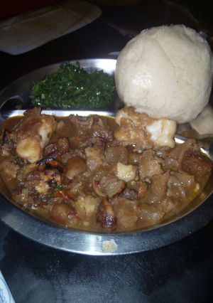 A picture of Boiled orenge with greens and ugali (bone soup).
