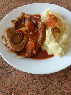 Una foto de Ossobuco en salsa de tomate con puré de papas