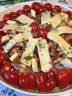 Une photo de Salade « plat complet » iceberg,tomates cerises,lard fumé,oignon rouge et cantal entre deux