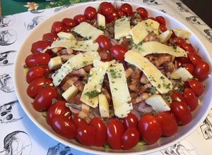 Une photo de Salade « plat complet » iceberg,tomates cerises,lard fumé,oignon rouge et cantal entre deux