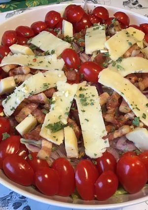 Une photo de Salade « plat complet » iceberg,tomates cerises,lard fumé,oignon rouge et cantal entre deux