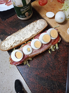 Una foto de Bocadillo de bacon, escarola, tomate, huevo duro y mayonesa