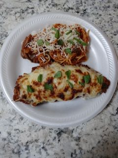 A picture of Chicken parmesan with a pasta side dish.