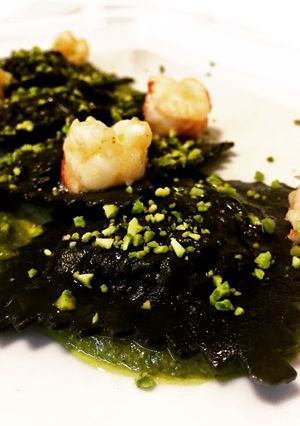 A picture of Black Ravioli with Sea Bream, Pistachio Pesto, and Seared Shrimp.
