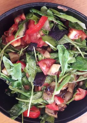 Una foto de Ensalada de rúcula, berenjena, tomate y lechuga😋😋😋