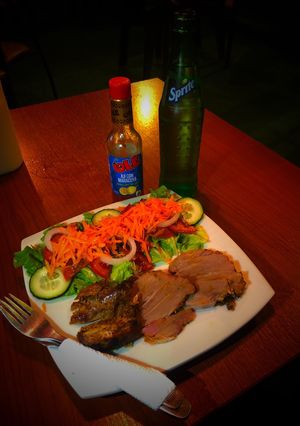 Una foto de Pernil con ensalada fresca