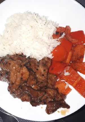 A picture of Sesame beef with 5 spice peppers and rice.
