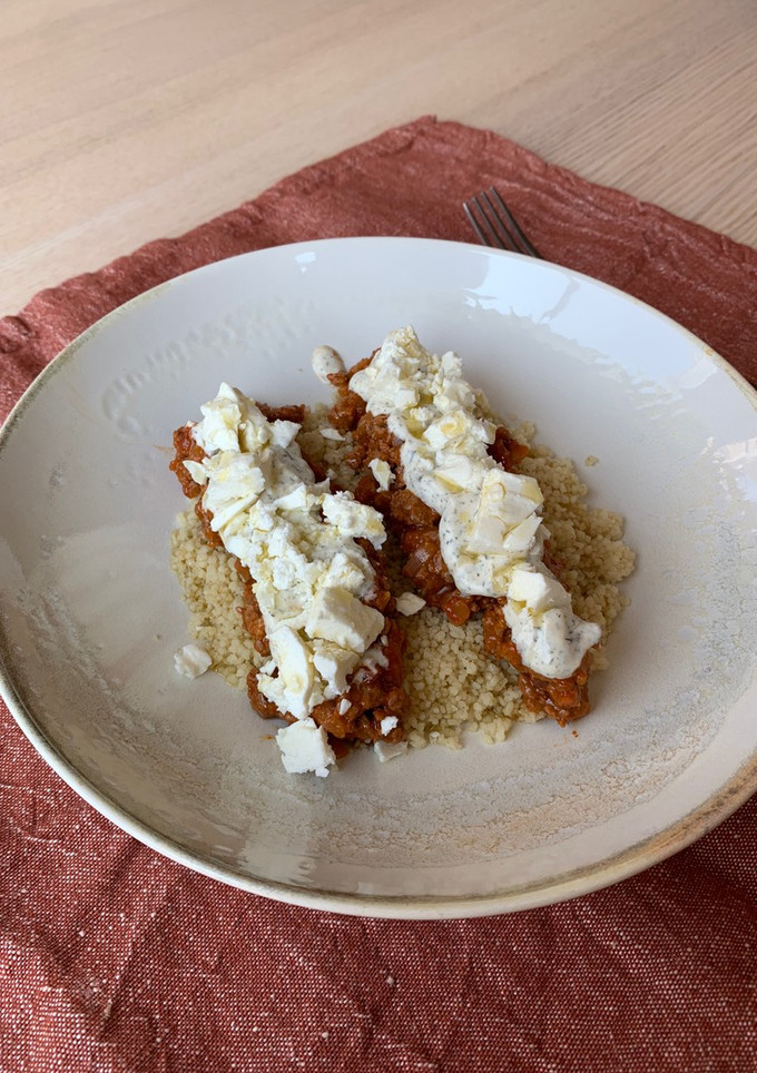 Una foto de Cous cous con bolognese, salsa de yogurt y feta