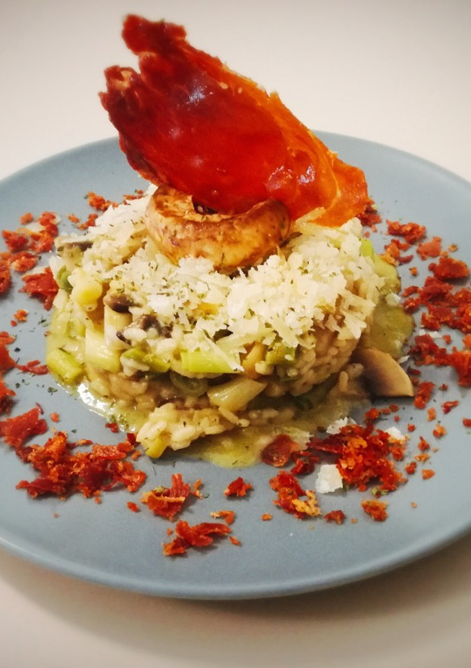Una foto de Risotto de verduras con queso manchego y crujiente de jamón