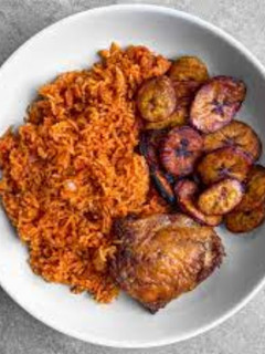 A picture of Jollof rice with fried chicken and plantain.