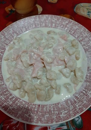 Una foto de Ñoquis caseros con salsa de jamón y queso