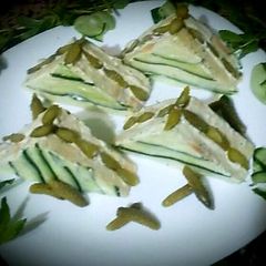 A picture of Tuna and mayonnaise sandwich, cheese, pickles.