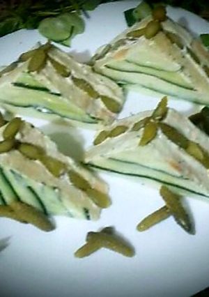 A picture of Tuna and mayonnaise sandwich, cheese, pickles.