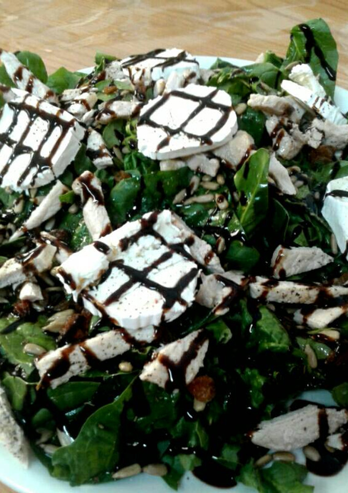 Una foto de Ensalada de espinacas con rulo de cabra y pollo